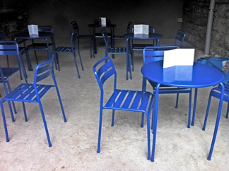 Photo: Blue chairs on concrete.